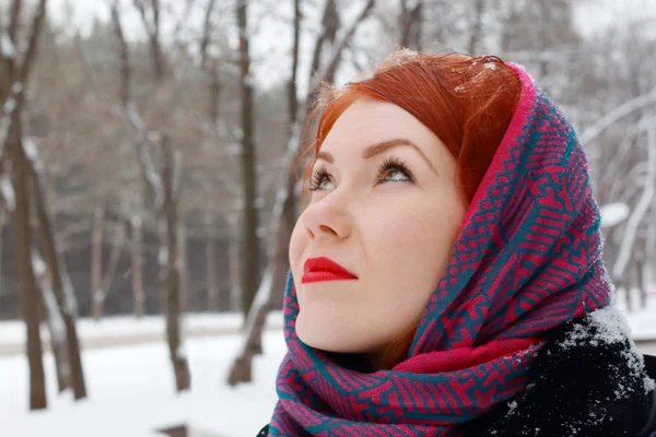 Pretty redhead girl in red kerchief looks up outdoor at winter d — Stock Photo, Image
