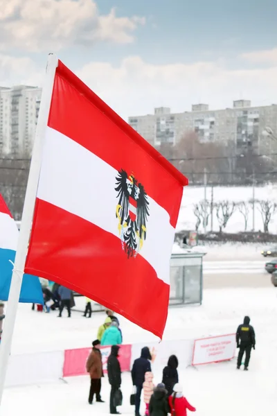 Flag of Austria on wind at winter cloudy day in street of city — Stock Photo, Image