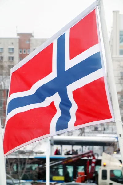 Flag of Norway on wind at winter cloudy day in street of city — Stock Photo, Image