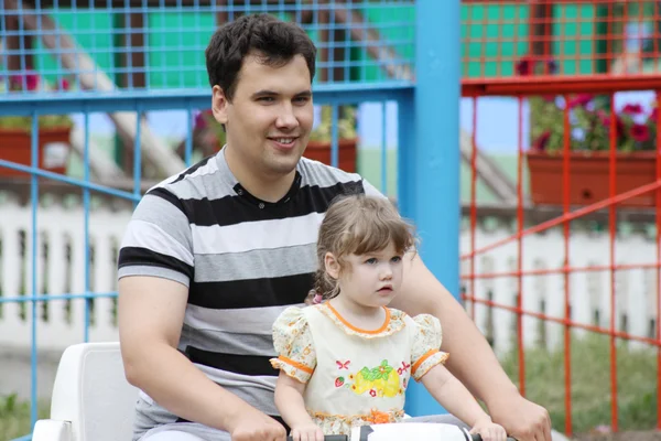 Mladý otec a krásná dcera jít na lodičky v letním parku na da — Stock fotografie