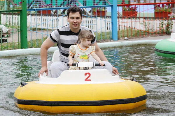 Smiling father and little daughter go boating in summer park at — Stock Photo, Image