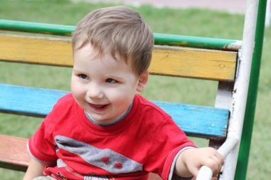 renkli salıncak sallanan neşeli küçük çocuk oturur