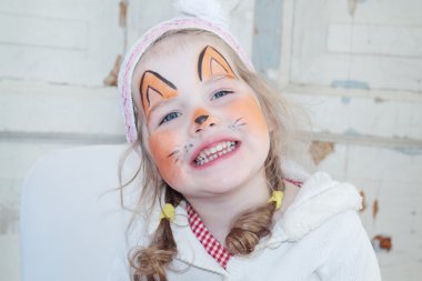 Little beautiful girl with face painting of fox unnatural smiles clipart