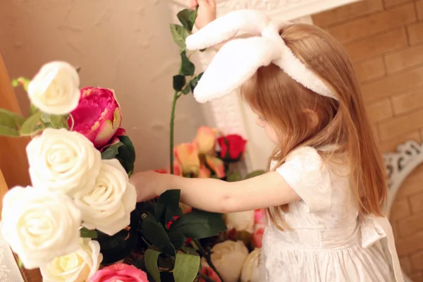 Pequena menina bonita em vestido branco e orelhas de coelho toca fluxo — Fotografia de Stock