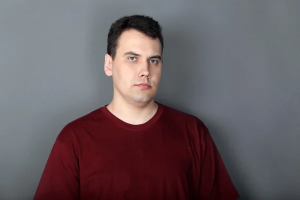 Porträt eines ernsthaften jungen Mannes im weinerlichen T-Shirt — Stockfoto