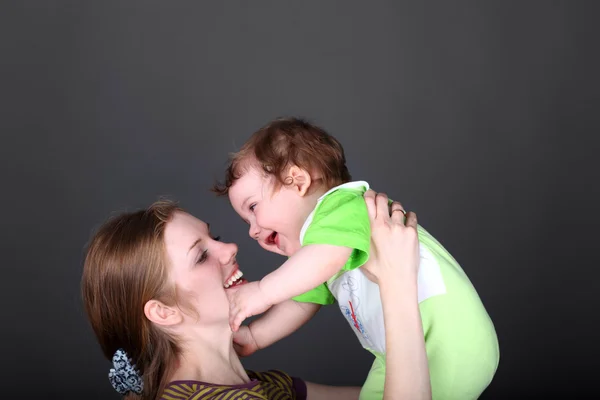 Porträt einer glücklichen Frau, die mit ihrem niedlichen kleinen Sohn spielt — Stockfoto