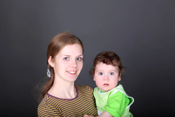 Ritratto di giovane madre felice con simpatico figlioletto in braccio — Foto Stock