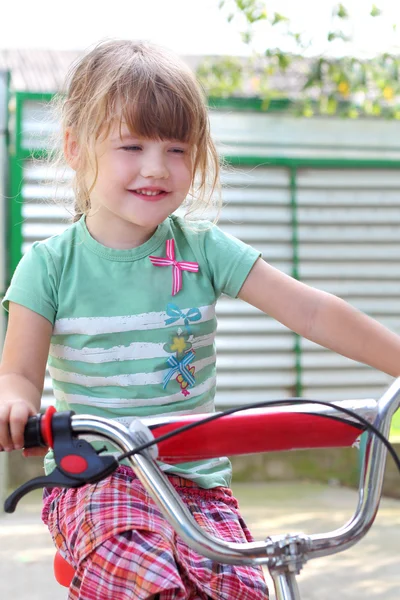 Glückliches kleines Mädchen mit Fahrrad im Hof — Stockfoto