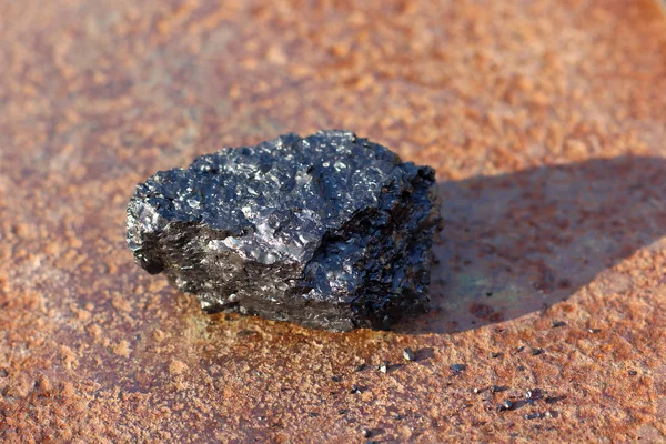 Svart sten kol ligger på rostig metallyta — Stockfoto