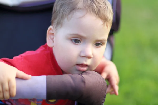 Portrait of small child who is sitting in baby carriage — Stock Photo, Image