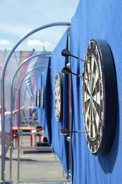 Dartboard con jabalinas en la pared azul en la calle en el día de verano — Foto de Stock