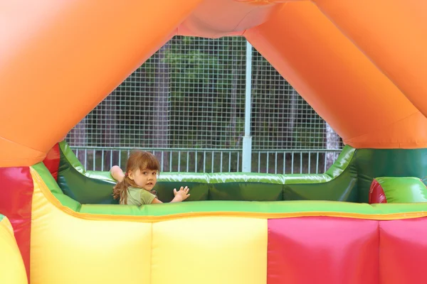 Bambina gioca in trampolino colorato aria nel parco divertimenti Immagine Stock