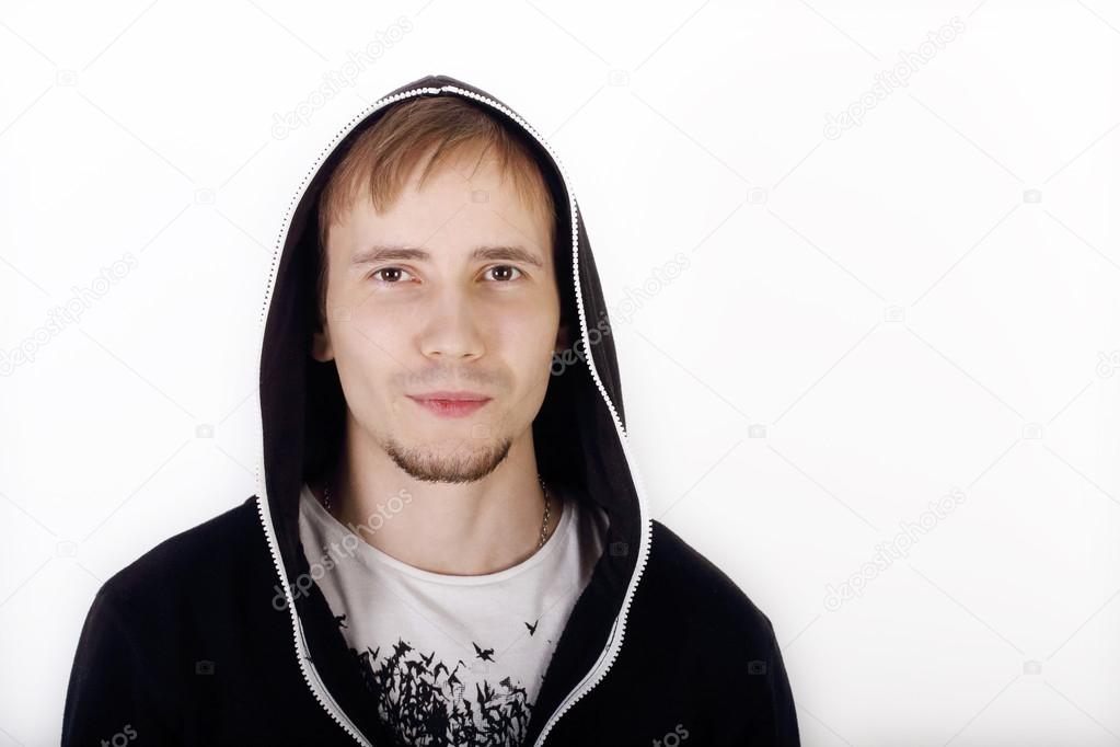 Young handsome man in black hoodies looks at camera in studio