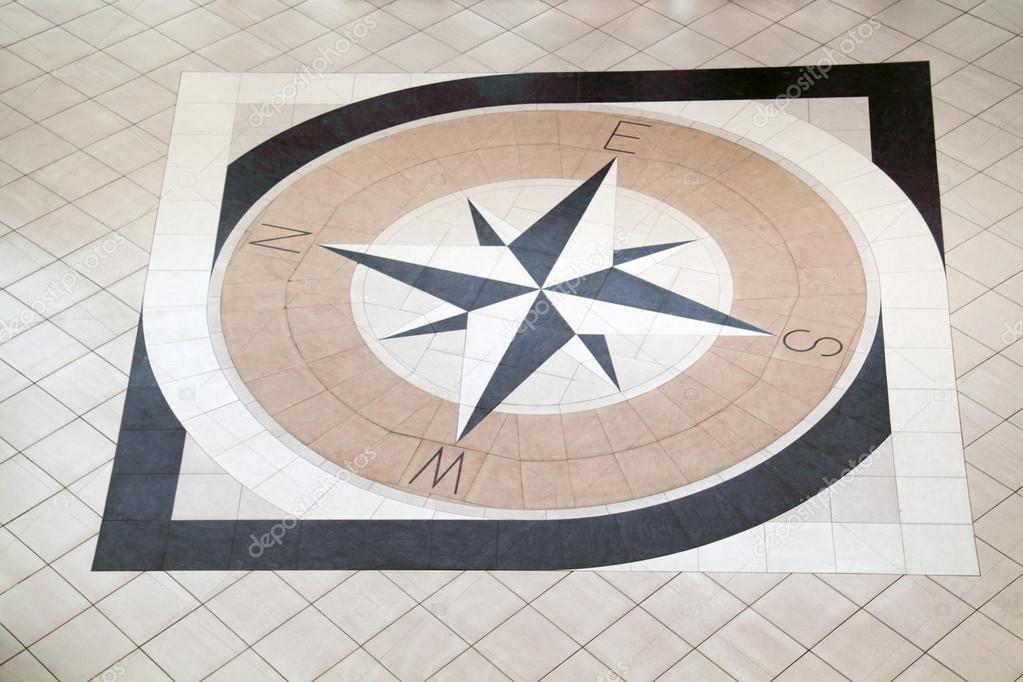 Large compass inlaid with black and light brown tiles on floor — Stock ...