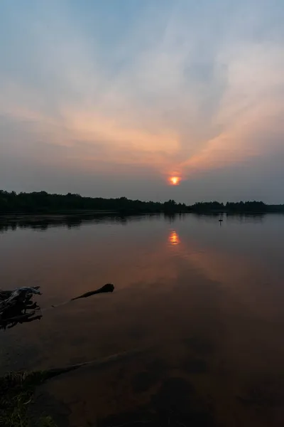 Schöner Sonnenuntergang am Flussufer, der ein schönes natürliches Licht erzeugt. — Stockfoto