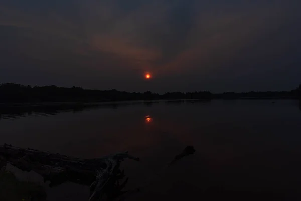 Schöner Sonnenuntergang am Flussufer, der ein schönes natürliches Licht erzeugt. — Stockfoto