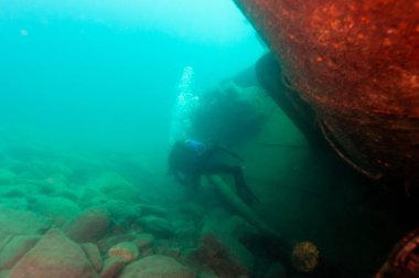 Superior Gölü 'nde bulunan büyük göl enkazını araştıran dalgıç.