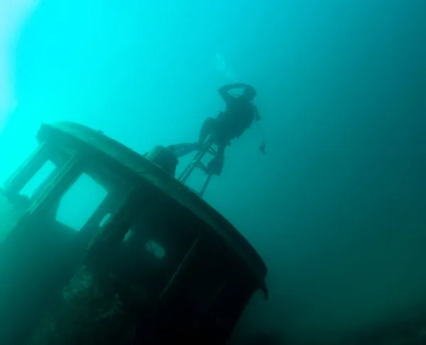 Potápěč salutovat, zatímco na vlečné lodi vrak v Lake Superior — Stock fotografie