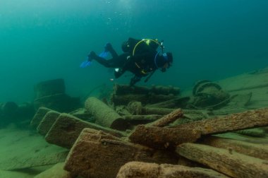 Munising, MI - 14 Ağustos 2021: SCUBA dalgıcı ahşap buharlı gemi enkazını keşfediyor