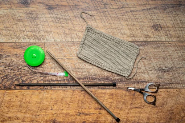 Swatch de malha de fio bege, fundo de madeira testando uma lã com peça de malha. — Fotografia de Stock