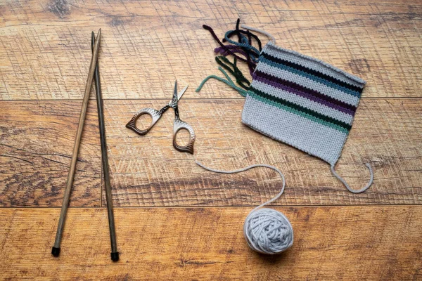 Relógio de malha branco e listrado, teste de fundo de madeira um com peça de malha — Fotografia de Stock