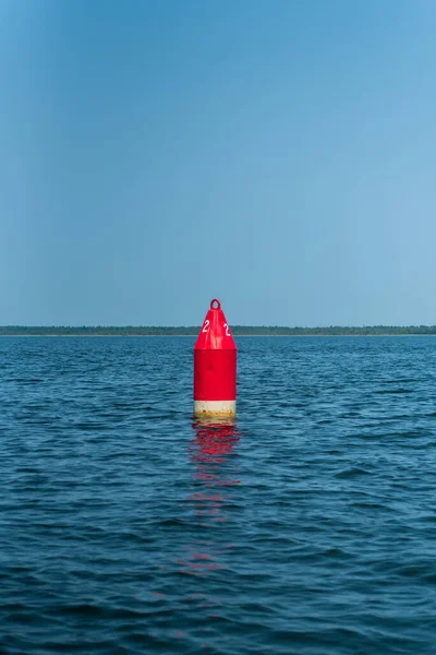 Een rode kanaalmarker leidt boten terwijl ze door de waterweg varen. — Stockfoto