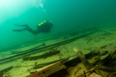 Munising, MI - 14 Ağustos 2021: SCUBA dalgıcı ahşap buharlı gemi enkazını keşfediyor