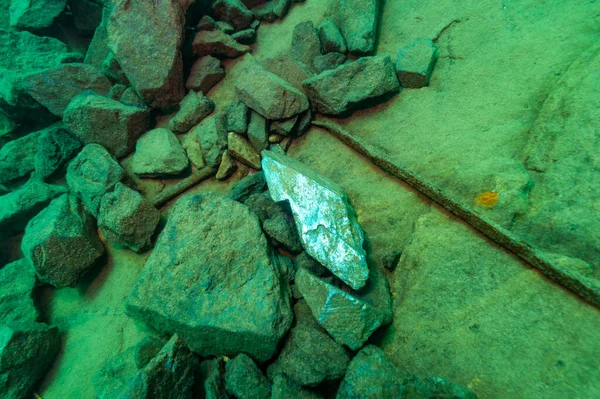 Underwater pile of virgin iron ore with one shiny ingot lost in shipwreck — Fotografia de Stock
