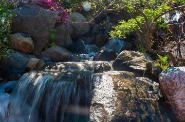 Beautiful small waterfall in a japanese style garden