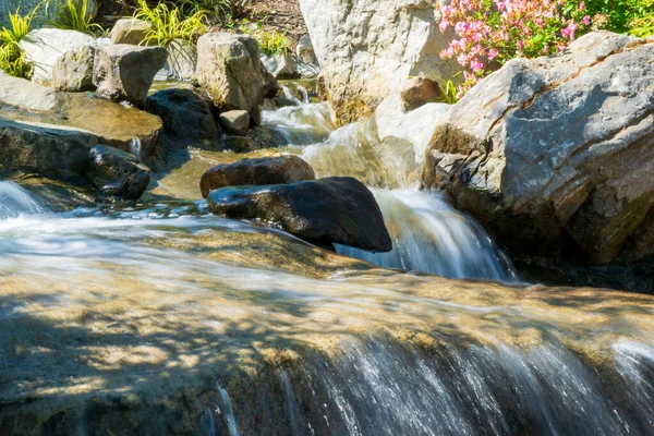 Primer plano de una pequeña cascada que muestra el movimiento en un jardín de estilo japonés — Foto de Stock