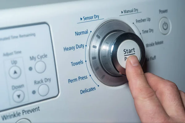 Finger pushing start button on electric dryer — Foto de Stock
