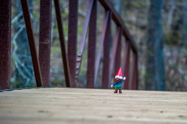 Gnome hiking on a bridge in the wilderness