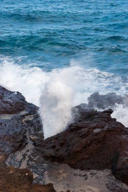 Oahu kıyısındaki bir hava deliğinden su fışkırıyor.