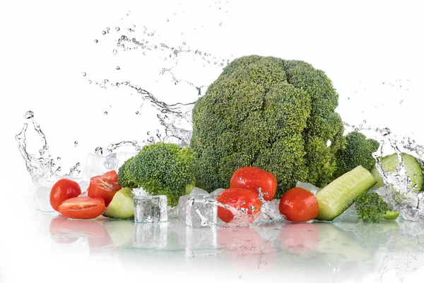 Vegetables water splash on a white background with ice cubes and crushed ice