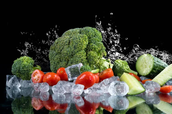 氷のキューブと砕いた氷と黒の背景に野菜の水のスプラッシュ — ストック写真