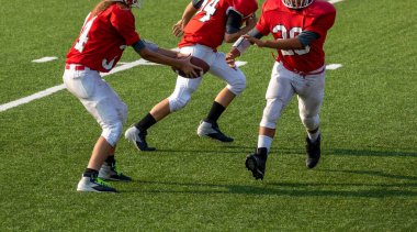 Football quarterback hand off ball to player. American football