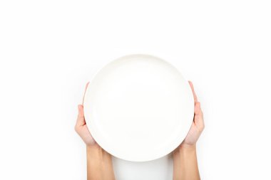 Beyaz arkaplanda izole edilmiş bir tabak seramiği tutan eller
