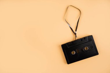 Pastel turuncu arka planda siyah kaliteli ses bandı. Metin için boşluk.