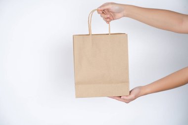 Azalt, kağıt torba erkek elinde gri arka plan üzerinde.