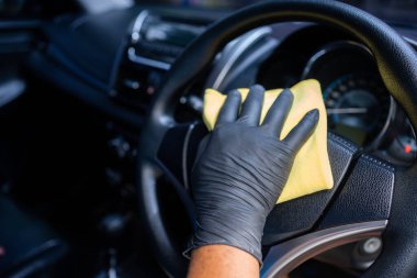 Arabayı kontrol paneli temizlemek için eldiven giyen adam. Oto Servisi.