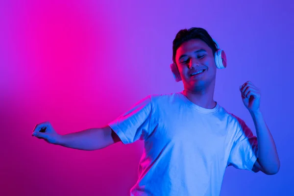 Sevdiği Müziğin Tadını Çıkarıyor Mavi Neon Arka Planda Dikilirken Kulaklıklı — Stok fotoğraf