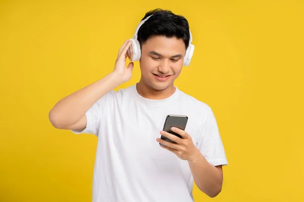 Kablosuz Kulaklık Takan Mutlu Asyalı Genç Adam Parlak Sarı Arka — Stok fotoğraf
