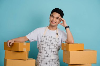 İşçi, açık mavi arka planda izole edilmiş kutular sağlar..