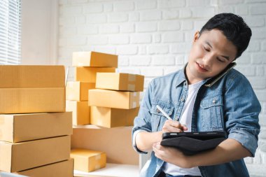 Girişimci akıllı telefon ya da tablet kullanarak paketleme paketinin hazırlanması için online alışveriş siparişini alır ve kontrol eder. Çevrimiçi fikirler satılıyor