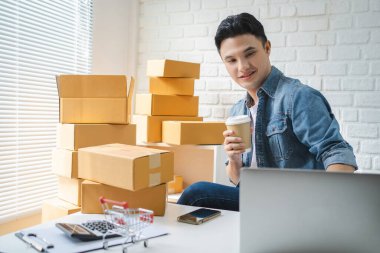 KOBİ sahipleri ellerinde sıcak kahve bardakları ve akıllı telefon ya da tablet kullanarak, kutuları hazırlamak için çevrimiçi sipariş alıp gözden geçiriyorlar. 