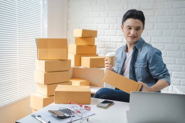Küçük işletmeler kuran KOBİ sahipleri, erkek girişimciler kutuların hazırlanması için çevrimiçi siparişleri almak ve gözden geçirmek üzere müşterilerle sohbet ediyorlar. KME iş fikirleri çevrimiçi.
