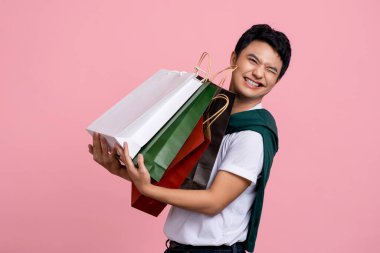 Genç Asyalı alışverişçi bir sürü alışveriş çantası taşıyor..