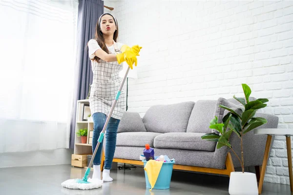 Oturma odasındaki evi profesyonel olarak temizleyen Asyalı güzel bir genç kadının vücut ölçüleri..