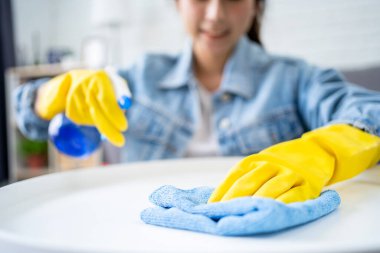 Beautiful young Asian woman cleaning house with microfiber rag. Housekeeping concept.