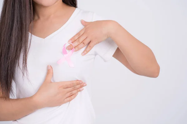 Close-up of a pink banner ribbon on a woman\'s chest in support of breast cancer causes and health care.